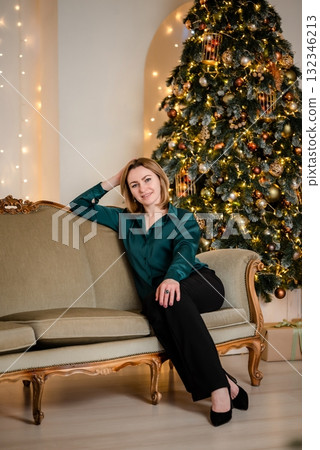 Woman Relaxing on Sofa by Christmas Tree at Home Woman Relaxing on Sofa by Christmas Tree at Home 132346213