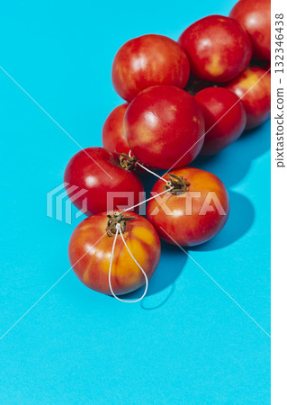 red tomatoes resting on a blue background 132346438