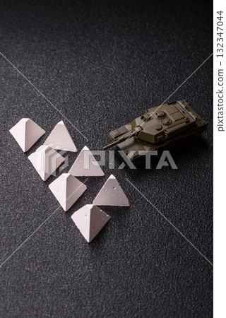 Anti-tank barrier or dragon's teeth made of concrete and iron as a fortification. Dragon's teeth Anti-tank barrier or dragon's teeth made of concrete and iron as a fortification. Dragon's teeth 132347044