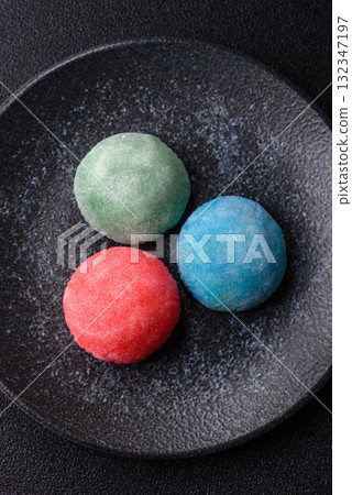 Japanese mochi, ice cream or Asian sweets with fruit filling. Mochi of different colors Japanese mochi, ice cream or Asian sweets with fruit filling. Mochi of different colors 132347197
