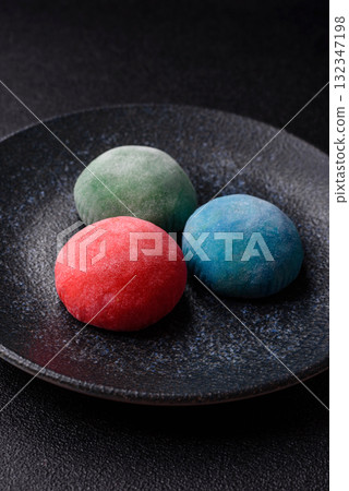 Japanese mochi, ice cream or Asian sweets with fruit filling. Mochi of different colors Japanese mochi, ice cream or Asian sweets with fruit filling. Mochi of different colors 132347198