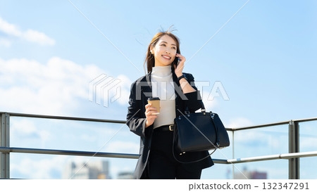 微笑的女人/女商人在智慧型手機上交談 微笑的女人/女商人在智慧型手機上交談 132347291