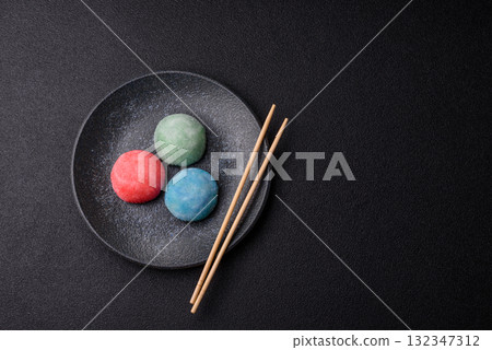 Japanese mochi, ice cream or Asian sweets with fruit filling. Mochi of different colors Japanese mochi, ice cream or Asian sweets with fruit filling. Mochi of different colors 132347312