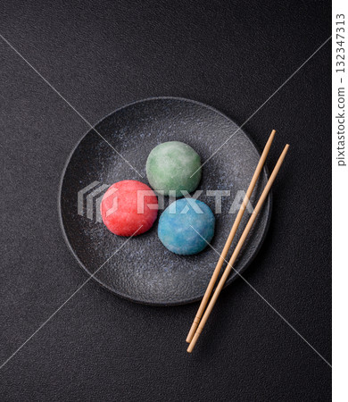 Japanese mochi, ice cream or Asian sweets with fruit filling. Mochi of different colors Japanese mochi, ice cream or Asian sweets with fruit filling. Mochi of different colors 132347313