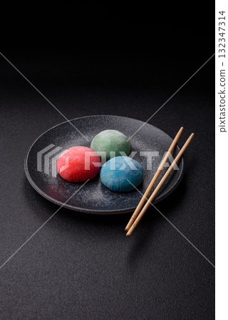 Japanese mochi, ice cream or Asian sweets with fruit filling. Mochi of different colors 132347314
