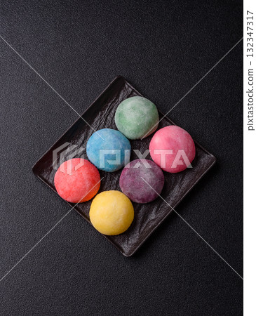 Japanese mochi, ice cream or Asian sweets with fruit filling. Mochi of different colors Japanese mochi, ice cream or Asian sweets with fruit filling. Mochi of different colors 132347317