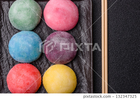Japanese mochi, ice cream or Asian sweets with fruit filling. Mochi of different colors Japanese mochi, ice cream or Asian sweets with fruit filling. Mochi of different colors 132347325