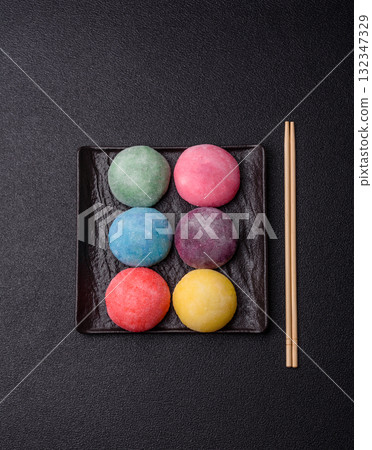Japanese mochi, ice cream or Asian sweets with fruit filling. Mochi of different colors Japanese mochi, ice cream or Asian sweets with fruit filling. Mochi of different colors 132347329