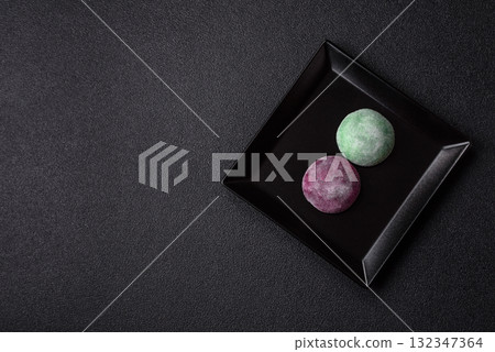 Japanese mochi, ice cream or Asian sweets with fruit filling. Mochi of different colors Japanese mochi, ice cream or Asian sweets with fruit filling. Mochi of different colors 132347364