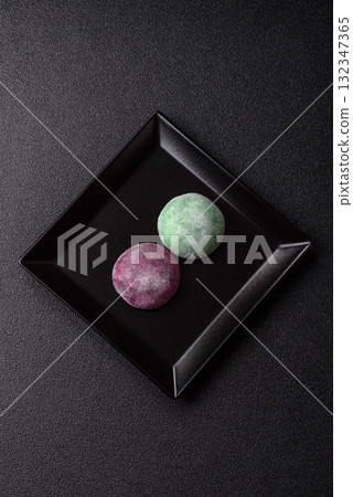 Japanese mochi, ice cream or Asian sweets with fruit filling. Mochi of different colors Japanese mochi, ice cream or Asian sweets with fruit filling. Mochi of different colors 132347365