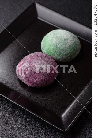 Japanese mochi, ice cream or Asian sweets with fruit filling. Mochi of different colors 132347370