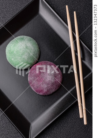Japanese mochi, ice cream or Asian sweets with fruit filling. Mochi of different colors Japanese mochi, ice cream or Asian sweets with fruit filling. Mochi of different colors 132347373