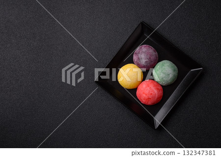 Japanese mochi, ice cream or Asian sweets with fruit filling. Mochi of different colors Japanese mochi, ice cream or Asian sweets with fruit filling. Mochi of different colors 132347381