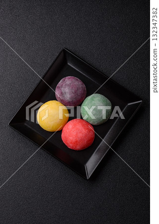 Japanese mochi, ice cream or Asian sweets with fruit filling. Mochi of different colors Japanese mochi, ice cream or Asian sweets with fruit filling. Mochi of different colors 132347382