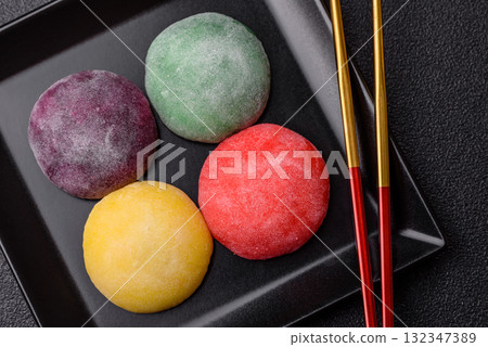 Japanese mochi, ice cream or Asian sweets with fruit filling. Mochi of different colors 132347389