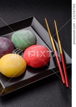 Japanese mochi, ice cream or Asian sweets with fruit filling. Mochi of different colors Japanese mochi, ice cream or Asian sweets with fruit filling. Mochi of different colors 132347391