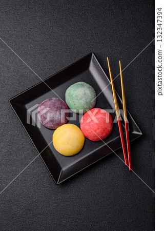 Japanese mochi, ice cream or Asian sweets with fruit filling. Mochi of different colors 132347394