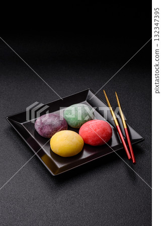 Japanese mochi, ice cream or Asian sweets with fruit filling. Mochi of different colors 132347395
