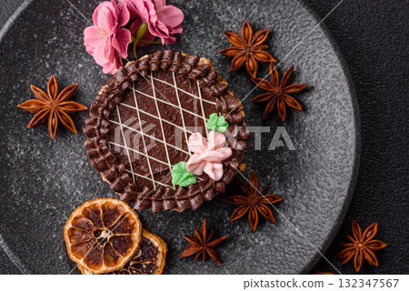 Sweet tart, pie with chocolate and cream with fruit filling on a plate. Chocolate tart 132347567
