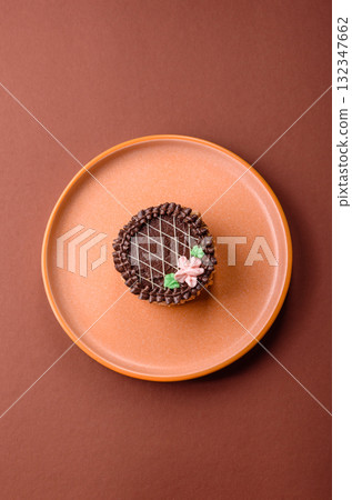 Sweet tart, pie with chocolate and cream with fruit filling on a plate. Chocolate tart 132347662