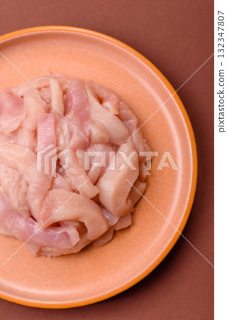 Raw chicken meat cut into strips, fresh fillet or breast slices. Chicken raw meat in pieces Raw chicken meat cut into strips, fresh fillet or breast slices. Chicken raw meat in pieces 132347807