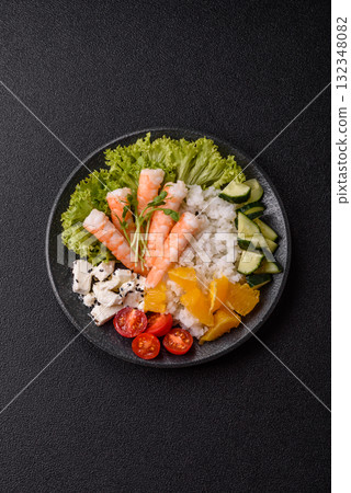 Bowl with shrimps, seafood, rice, oranges, tomatoes with sauce. Bowl with prawns 132348082