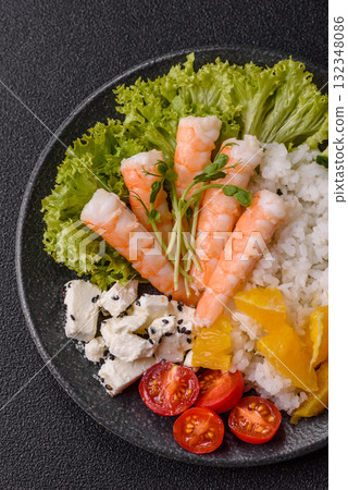 Bowl with shrimps, seafood, rice, oranges, tomatoes with sauce. Bowl with prawns 132348086