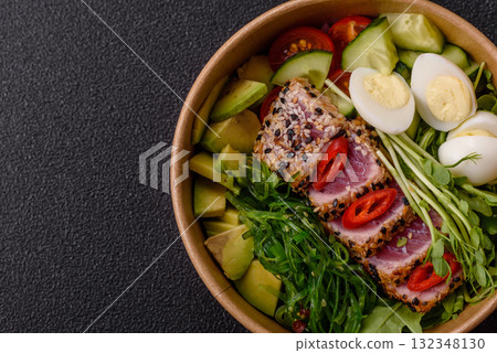 Seafood bowl, tuna tataki fillet slices with rice, oranges, tomatoes and sauce. Tuna bowl Seafood bowl, tuna tataki fillet slices with rice, oranges, tomatoes and sauce. Tuna bowl 132348130