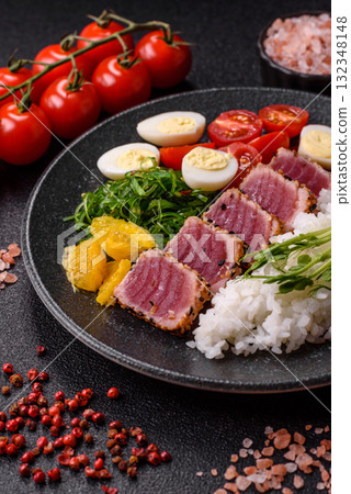 Seafood bowl, tuna tataki fillet slices with rice, oranges, tomatoes and sauce. Tuna bowl Seafood bowl, tuna tataki fillet slices with rice, oranges, tomatoes and sauce. Tuna bowl 132348148