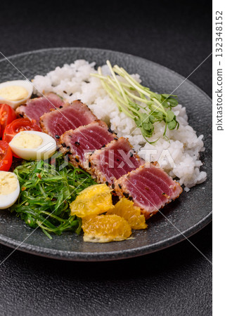 Seafood bowl, tuna tataki fillet slices with rice, oranges, tomatoes and sauce. Tuna bowl Seafood bowl, tuna tataki fillet slices with rice, oranges, tomatoes and sauce. Tuna bowl 132348152