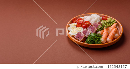 Seafood bowl, tuna tataki fillet slices with rice, oranges, tomatoes and sauce. Tuna bowl Seafood bowl, tuna tataki fillet slices with rice, oranges, tomatoes and sauce. Tuna bowl 132348157