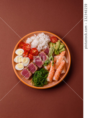 Seafood bowl, tuna tataki fillet slices with rice, oranges, tomatoes and sauce. Tuna bowl Seafood bowl, tuna tataki fillet slices with rice, oranges, tomatoes and sauce. Tuna bowl 132348159