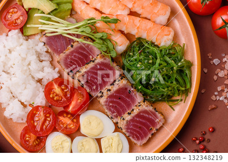 Seafood bowl, tuna tataki fillet slices with rice, oranges, tomatoes and sauce. Tuna bowl 132348219