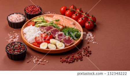 Seafood bowl, tuna tataki fillet slices with rice, oranges, tomatoes and sauce. Tuna bowl Seafood bowl, tuna tataki fillet slices with rice, oranges, tomatoes and sauce. Tuna bowl 132348222