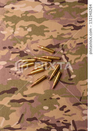 Machine gun cartridges on a camouflage background, military wallpaper. Camouflage background 132348264