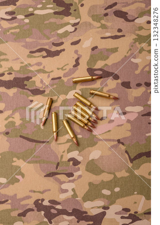 Machine gun cartridges on a camouflage background, military wallpaper. Camouflage background Machine gun cartridges on a camouflage background, military wallpaper. Camouflage background 132348276