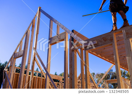 Construction workers are framing house at beams teamwork safety in home building. Construction workers are framing house at beams teamwork safety in home building. 132348505