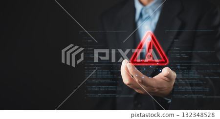 A businessman holds a glowing red warning triangle with an exclamation mark, symbolizing alert, caution, and cybersecurity threat in digital systems, with code elements in the background. 132348528