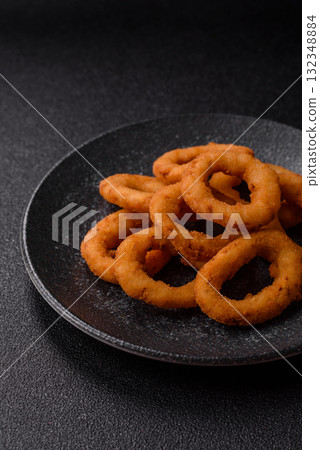 Onion rings or fried squid in breadcrumbs with sauce, takeaway food. Onion rings fried 132348884