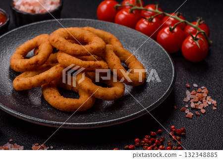 Onion rings or fried squid in breadcrumbs with sauce, takeaway food. Onion rings fried Onion rings or fried squid in breadcrumbs with sauce, takeaway food. Onion rings fried 132348885