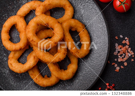 Onion rings or fried squid in breadcrumbs with sauce, takeaway food. Onion rings fried 132348886