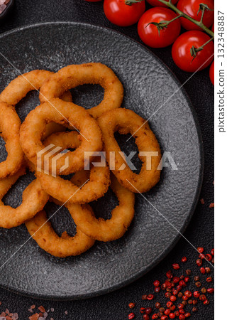 Onion rings or fried squid in breadcrumbs with sauce, takeaway food. Onion rings fried Onion rings or fried squid in breadcrumbs with sauce, takeaway food. Onion rings fried 132348887