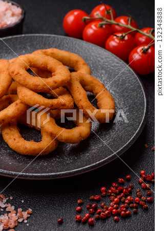 Onion rings or fried squid in breadcrumbs with sauce, takeaway food. Onion rings fried 132348888
