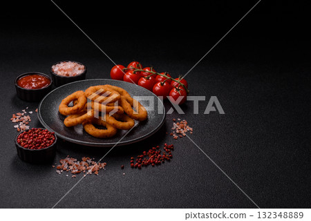 Onion rings or fried squid in breadcrumbs with sauce, takeaway food. Onion rings fried 132348889