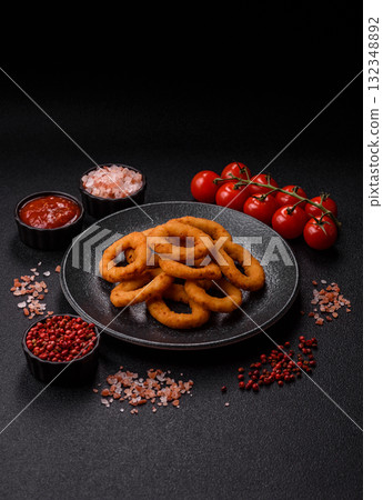 Onion rings or fried squid in breadcrumbs with sauce, takeaway food. Onion rings fried Onion rings or fried squid in breadcrumbs with sauce, takeaway food. Onion rings fried 132348892