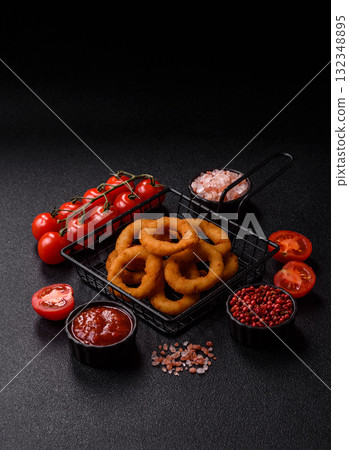 Onion rings or fried squid in breadcrumbs with sauce, takeaway food. Onion rings fried Onion rings or fried squid in breadcrumbs with sauce, takeaway food. Onion rings fried 132348895
