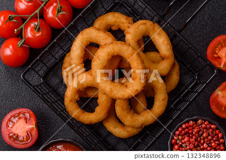 Onion rings or fried squid in breadcrumbs with sauce, takeaway food. Onion rings fried Onion rings or fried squid in breadcrumbs with sauce, takeaway food. Onion rings fried 132348896