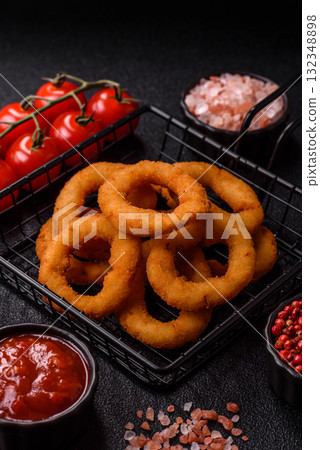 Onion rings or fried squid in breadcrumbs with sauce, takeaway food. Onion rings fried 132348898