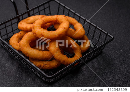 Onion rings or fried squid in breadcrumbs with sauce, takeaway food. Onion rings fried 132348899