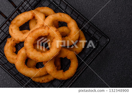 Onion rings or fried squid in breadcrumbs with sauce, takeaway food. Onion rings fried Onion rings or fried squid in breadcrumbs with sauce, takeaway food. Onion rings fried 132348900